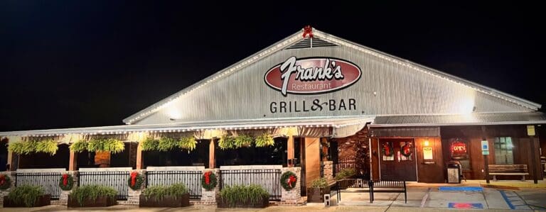 Frank's Restaurant Grill & Bar, adorned with greenery and wreaths on the front porch, now features an inviting herb garden installation that complements its vibrant ambiance.